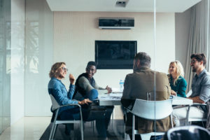 Group of people in a room showing how to decrease the number of work meetings
