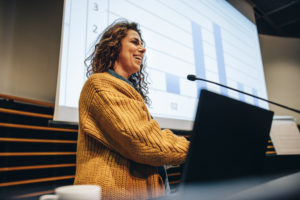 woman presenting in front of a projector