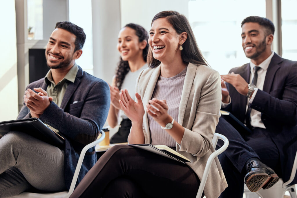 Shot of a group of Gen Z attorneys clapping hands in a meeting at work