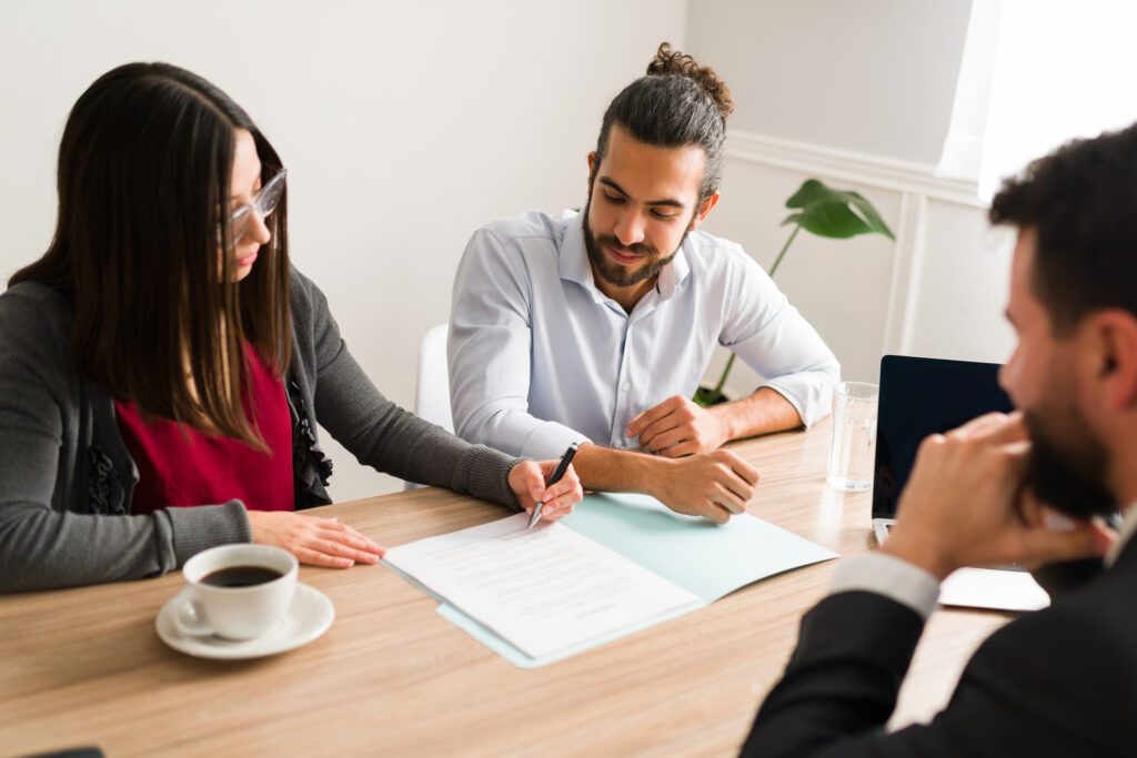 middle-class legal help; Newly married couple signing the papers and doing the legal procedure to buy a new house with a mortgage