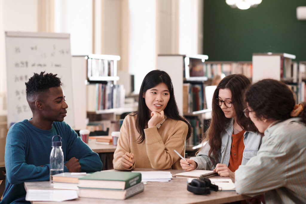 Illinois law students International group of students sitting at table in college library and studying together with focus on young Asian woman