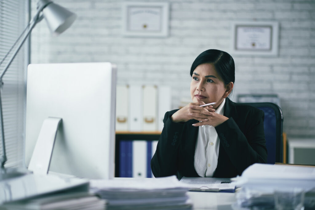 Pensive Vietnamese female attorney sitting in front of computer aba profile of the legal profession